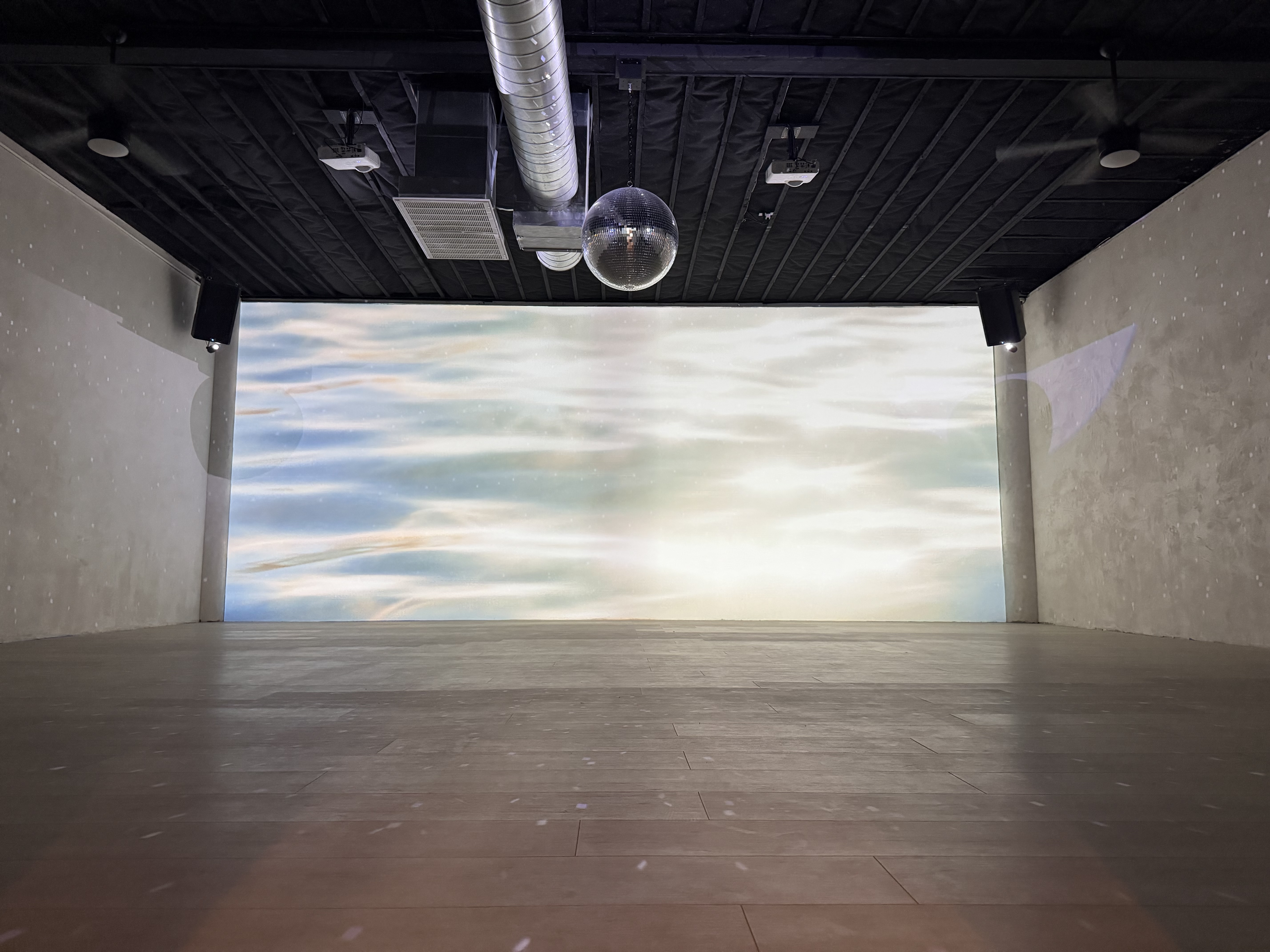 Sweat Equity studio with a disco ball and a projected sky on the back wall
